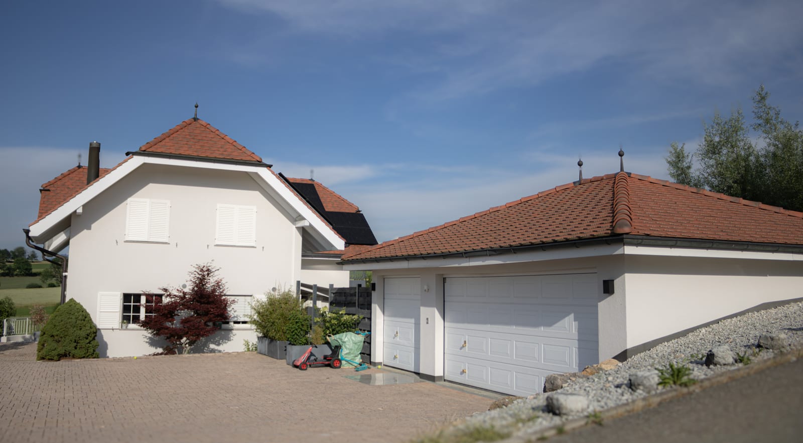 Façade avant de la villa d'Ependes après rénovation, avec garage double