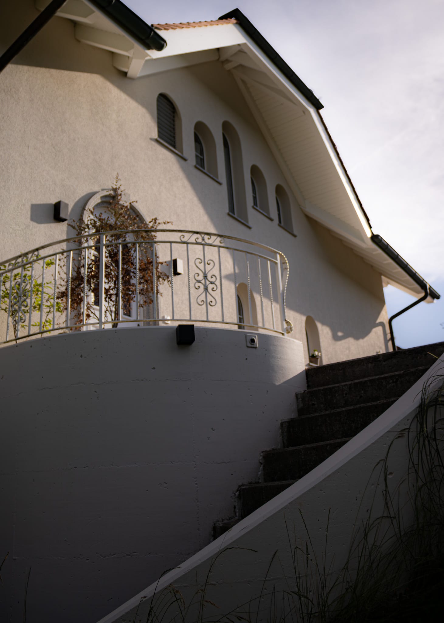 Escalier extérieur et balcon en fer forgé de la villa d'Ependes, crépi remis à neuf