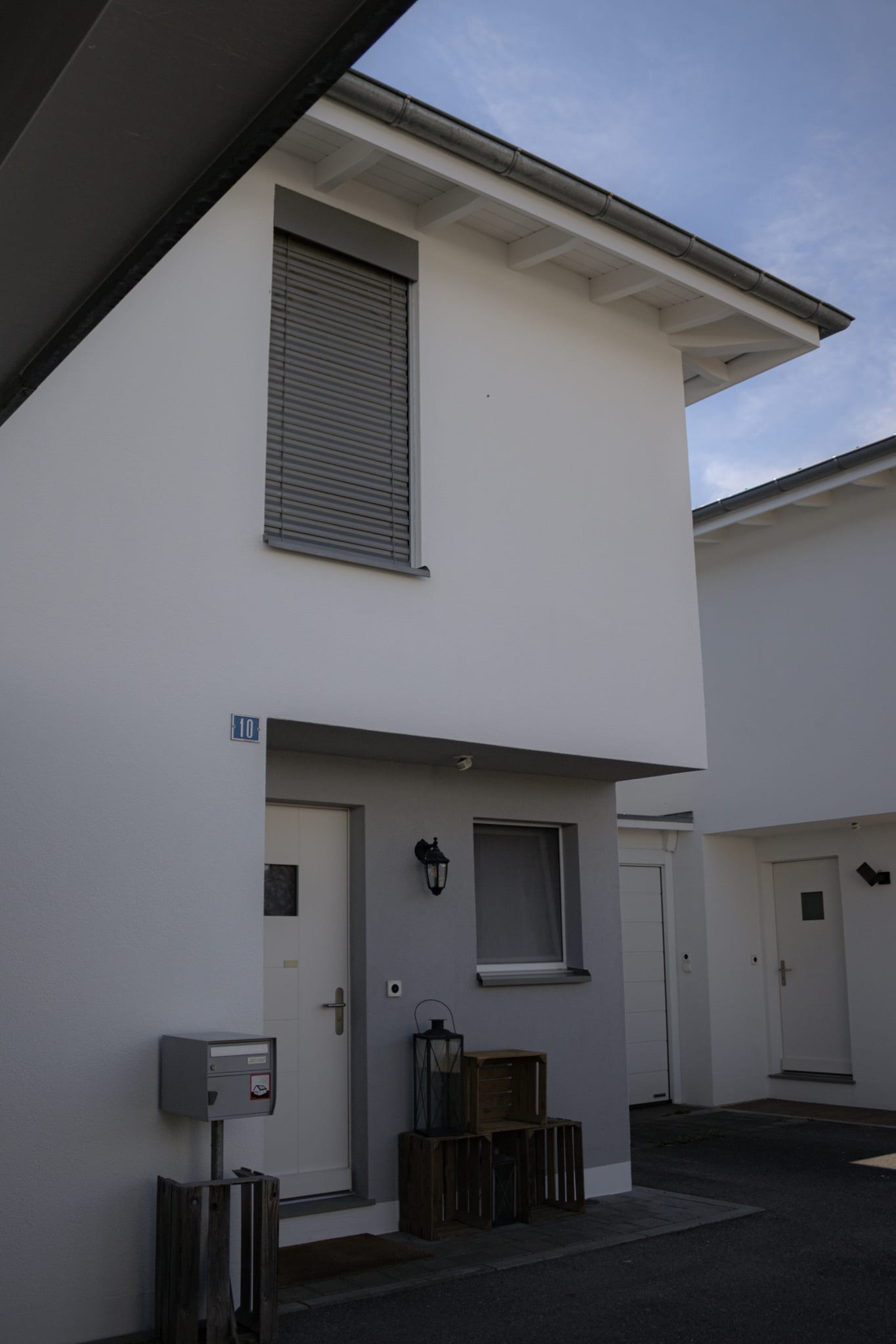 Détail de la façade blanche de Neyruz avec stores gris, après mise en peinture