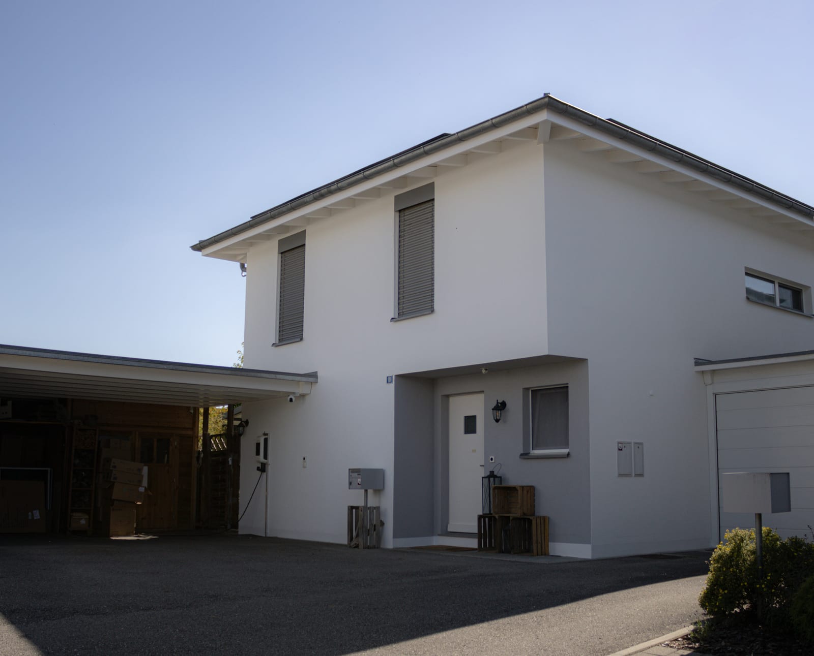 Maison de Neyruz après rénovation, façade blanche et couvert à voiture