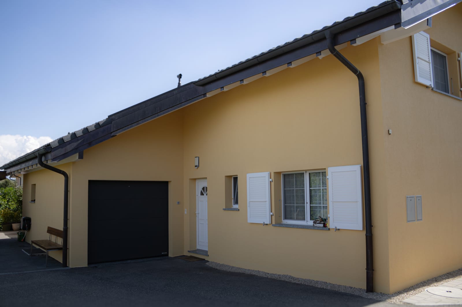 Maison d'Avry-sur-Matran après rénovation de façade et de toiture, teinte crème