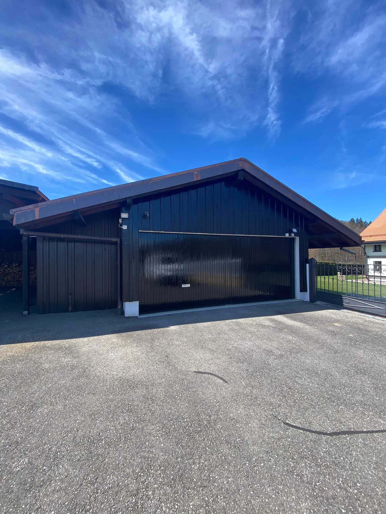 Garage de Villarsel-sur-Marly après rénovation, bardage bois verni foncé